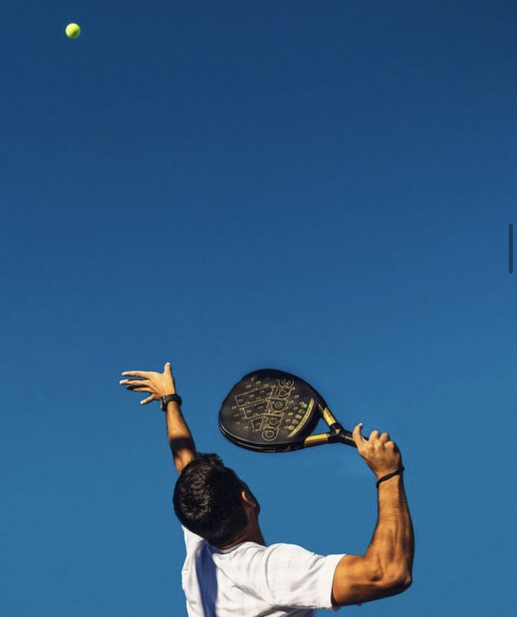 Joueur de padel au service en plein action